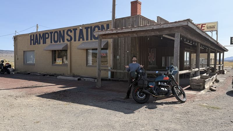 A rider posing beside the Bear 650 in front of Hampton Station