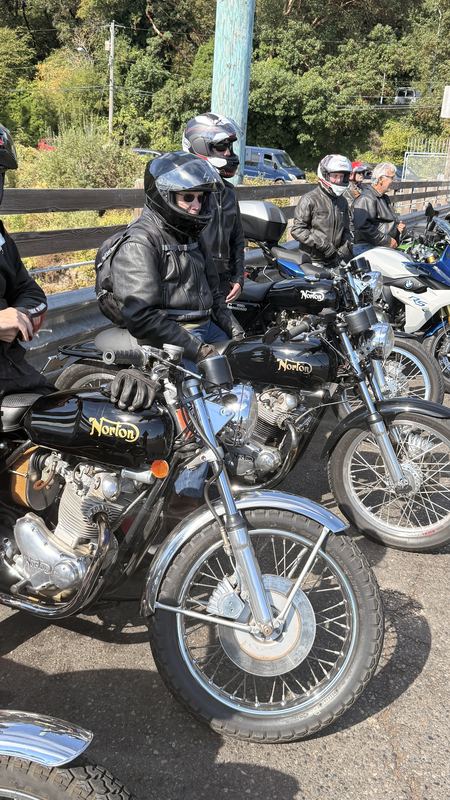 Norton motorcycles parked side by side with riders in helmets