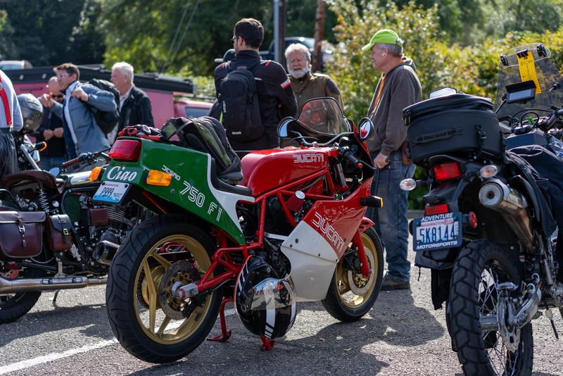 A red, white and green Italian sport bike parked with people standing behind it