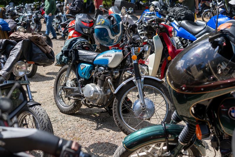 Vintage motorcycles parked packed close together at the gathering