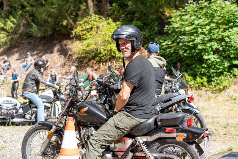 A rider in a helmet looking back at the camera, orange traffic cones behind